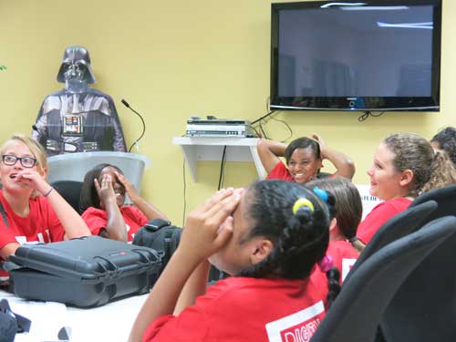 Girls laughing, sitting around a table with a Darth Vader cutout