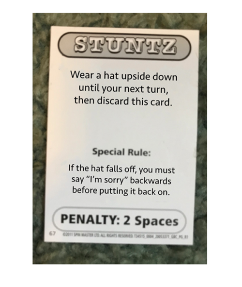 Action card from Quelf. Text on the card reads: Wear a hat upside down until your next turn, then discard a card