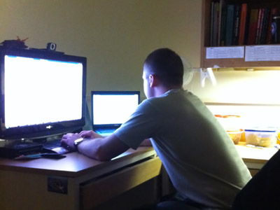 A cadet works at his desk in the barracks.