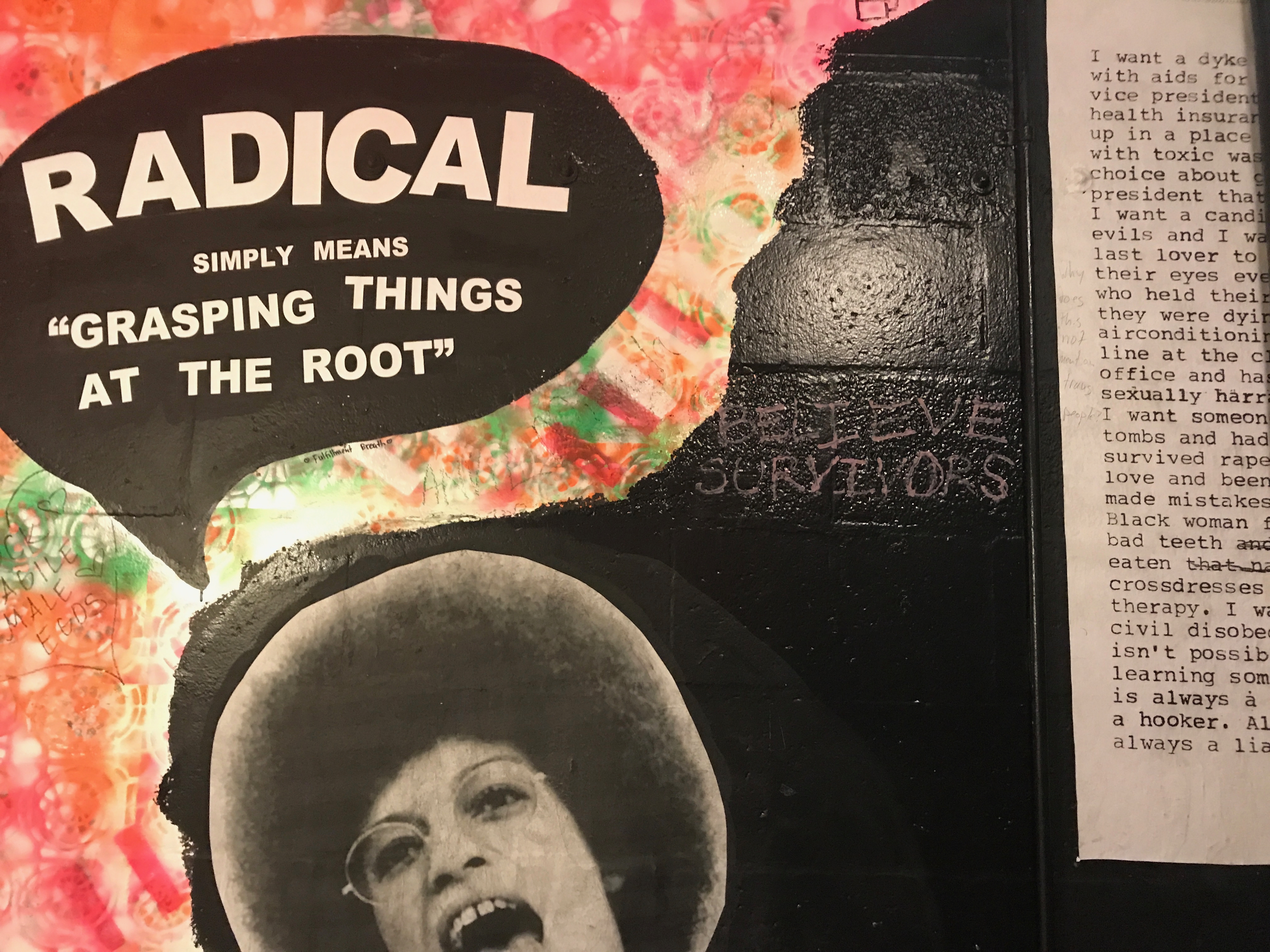 a painting on a wall of activist Angela Davis with a speech bubble saying 
