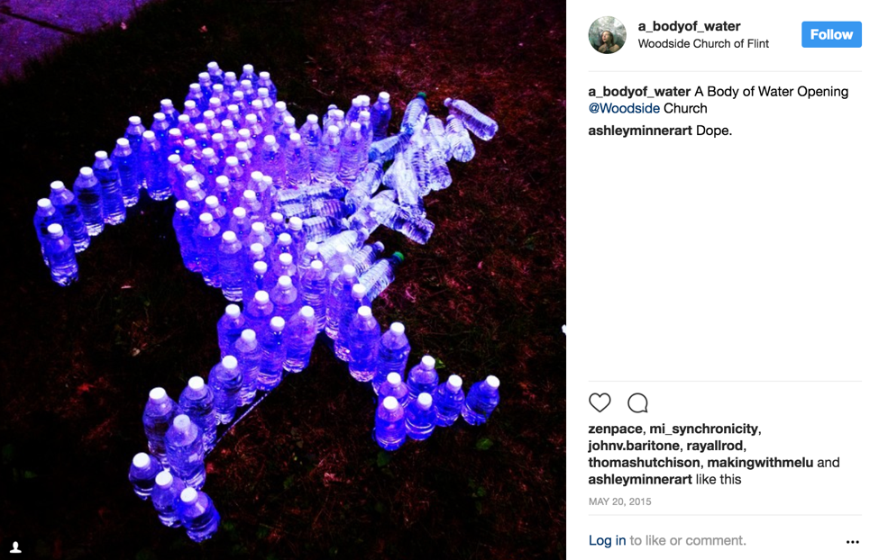 Screen shot of A Body of Water Instagram post that shows water bottle installation lit up at night